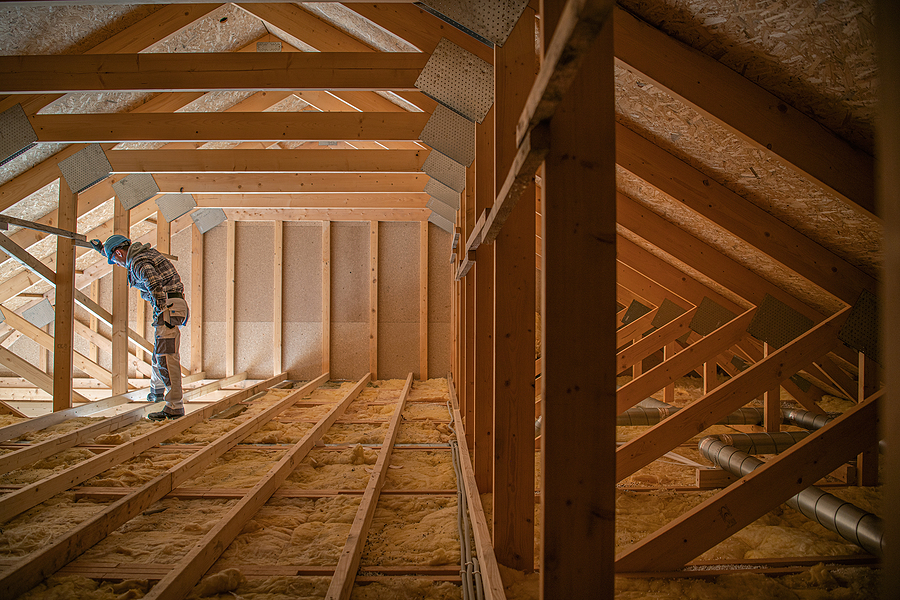 construction worker looking downstairs. attic wooden roof constr